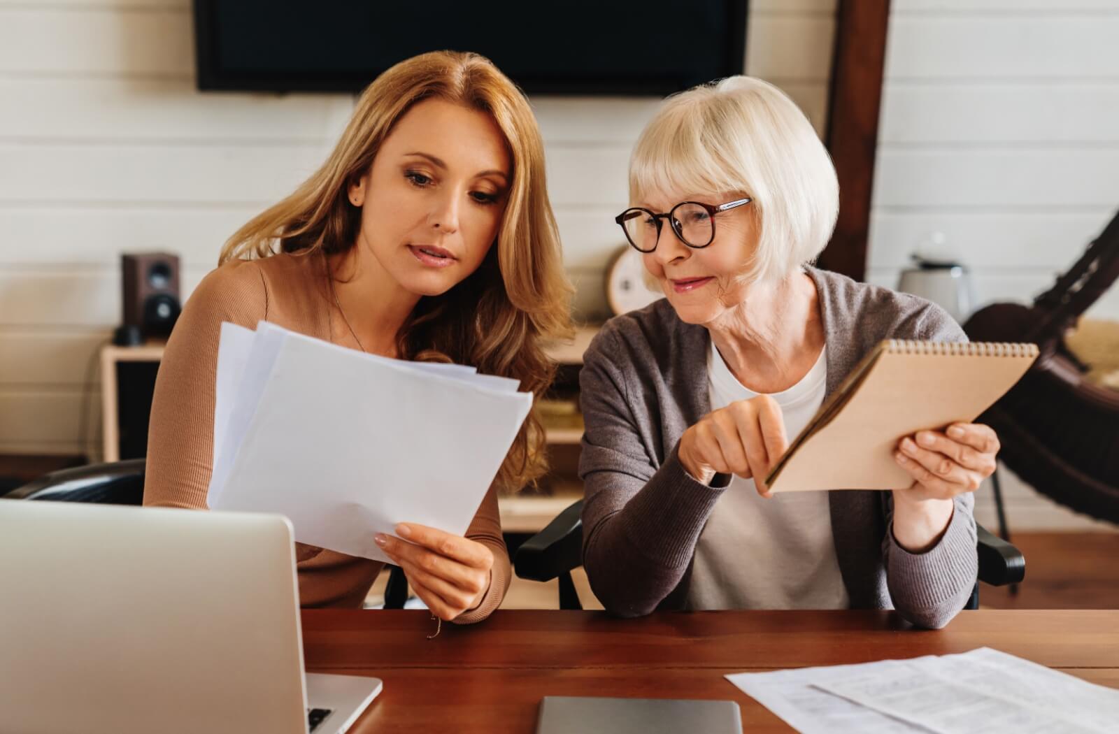 An adult spends an afternoon helping their older parent figure out legal documents after a dementia diagnosis
